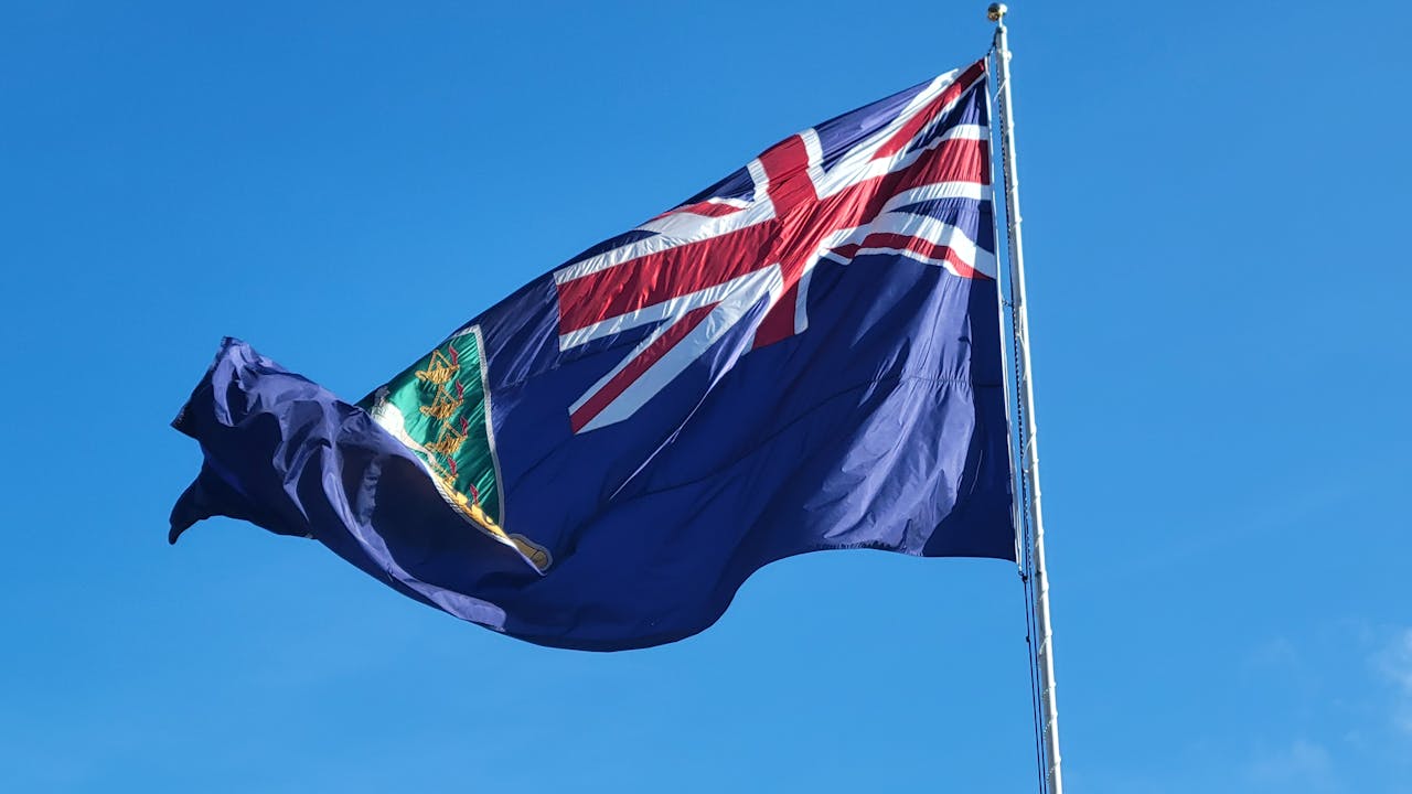 why-choose-us British Virgin Islands flag waving against a clear blue sky, symbolizing national pride.